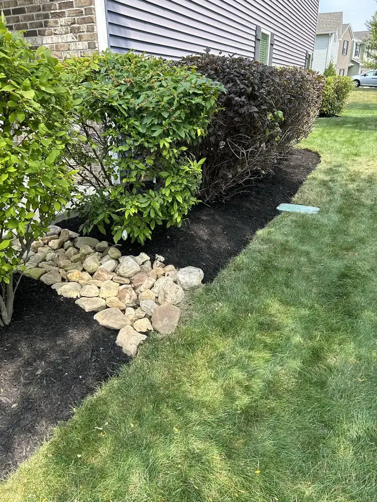 River rock accent in a planting bed