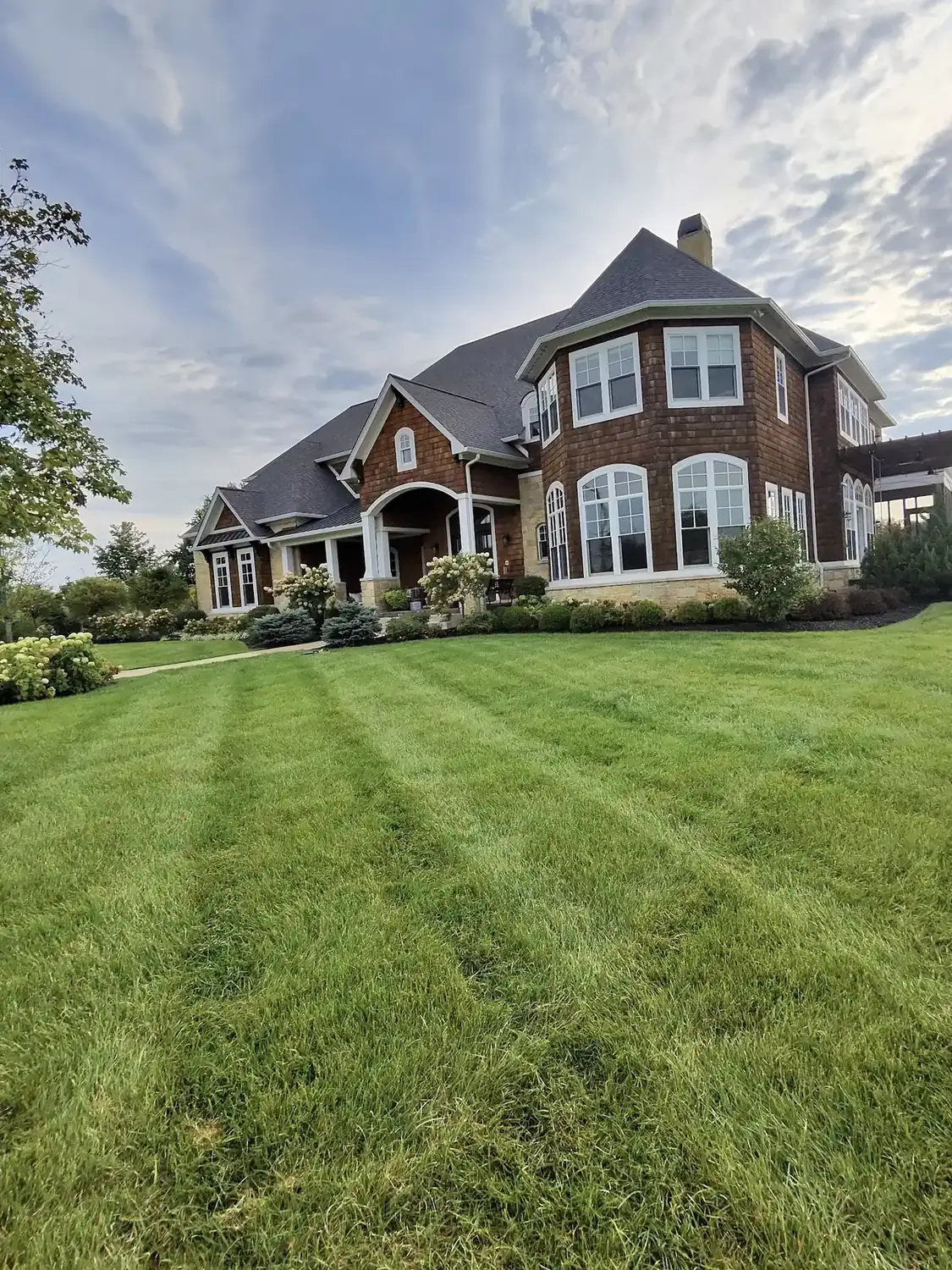 Freshly mowed striped lawn and landscaped front yard by Js Design Landscaping and Lawncare